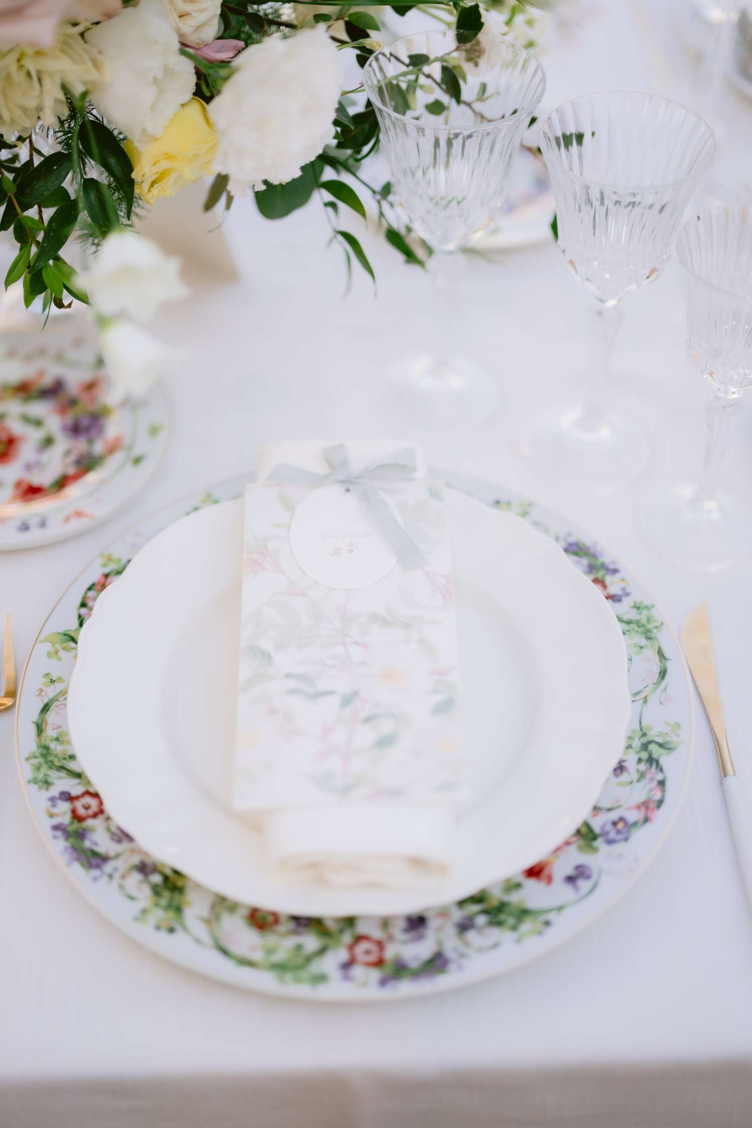 Pastel Menu on White Table Setting Next to Cocktail Glasses at Wedding Reception