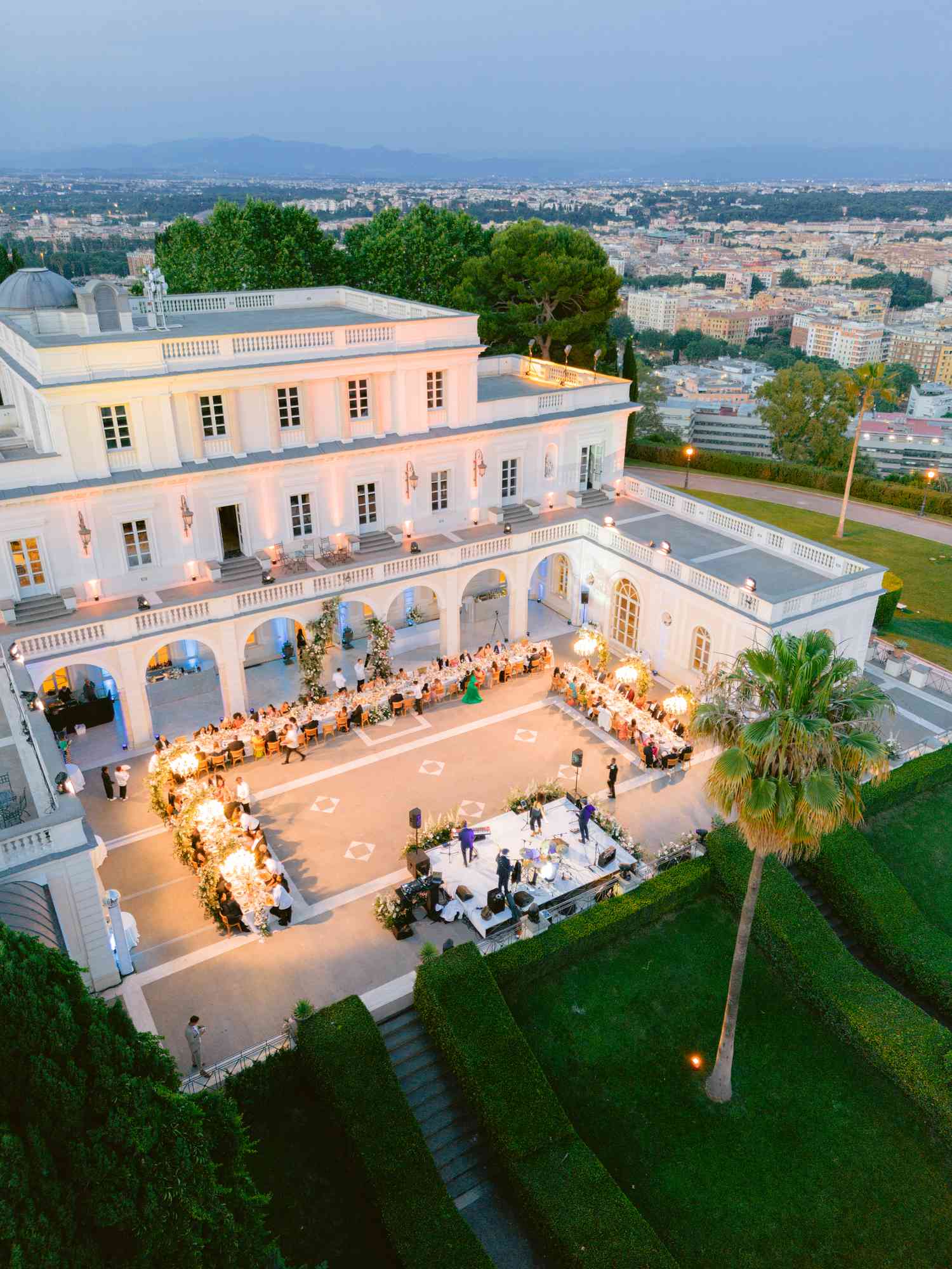 Wedding Reception in Courtyard of White Villa With City in Background