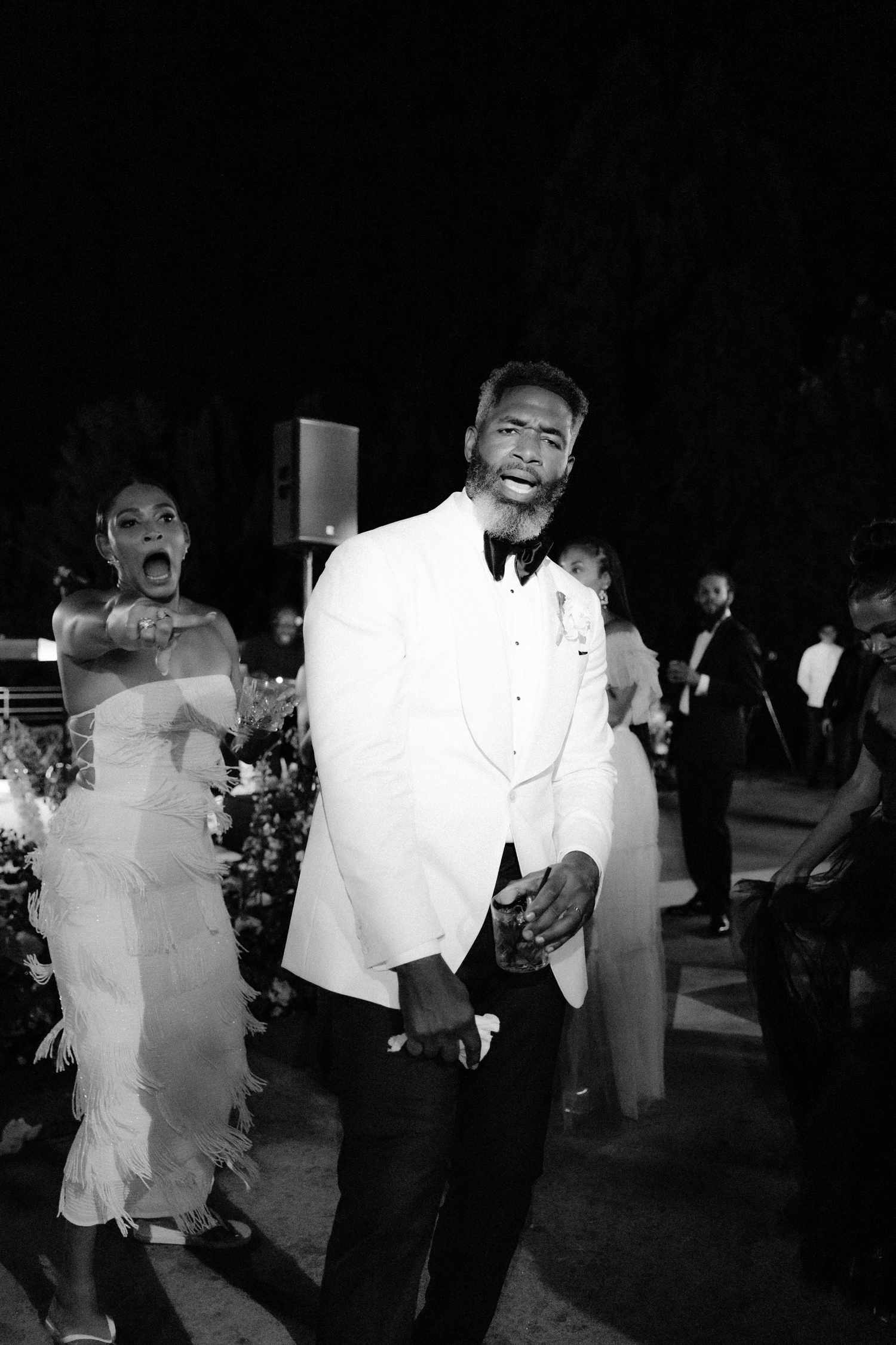 Black and White Picture of Bride in White Fringe Reception Dress Dancing With Groom in Tuxedo
