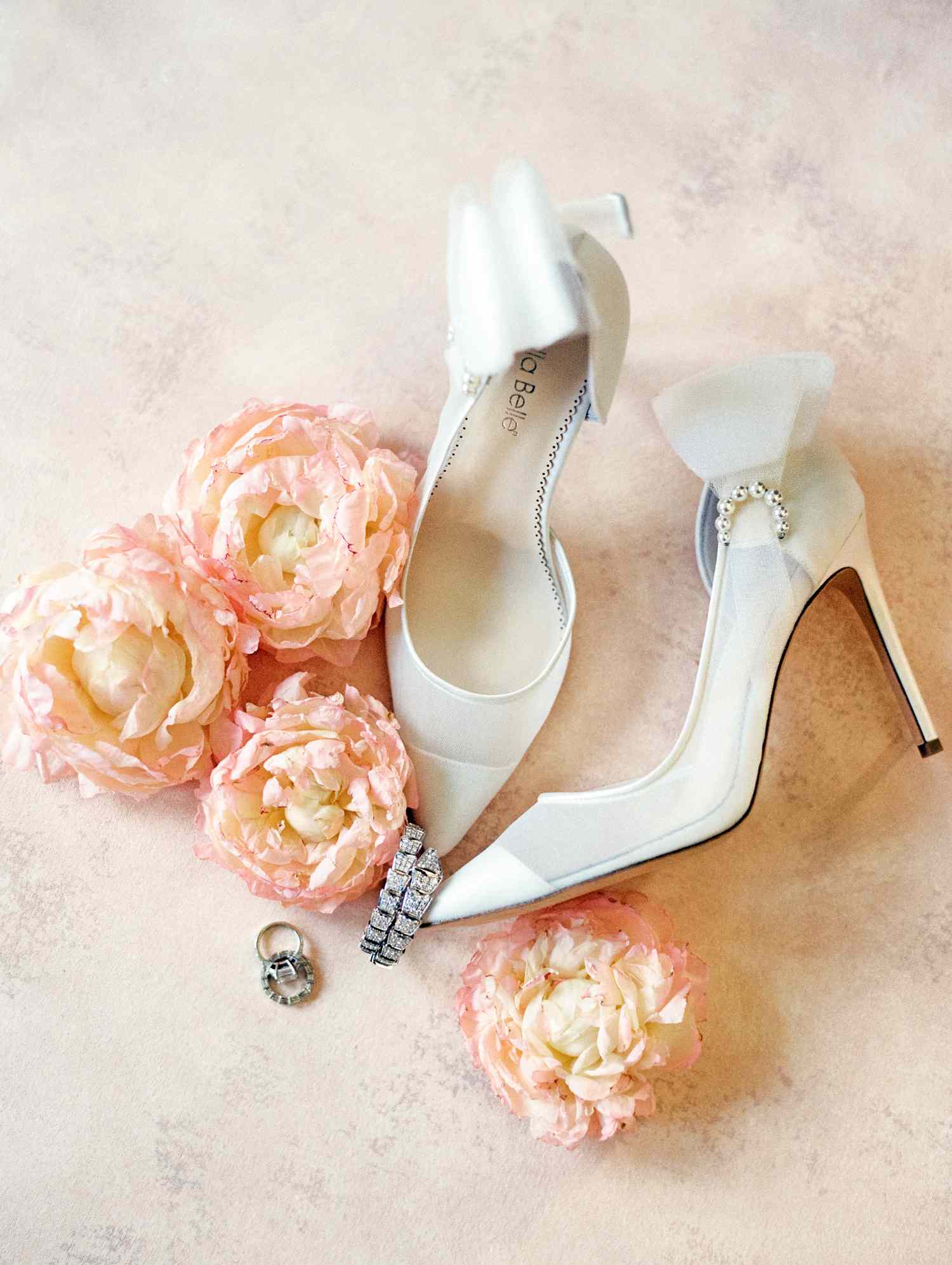 white wedding heels surrounded by pink flowers