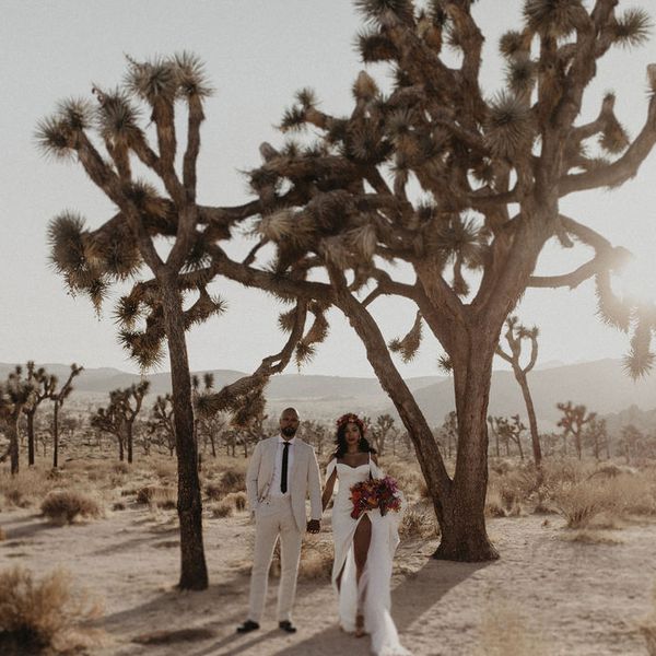 newlyweds walking hand in hand in joshua tree desert