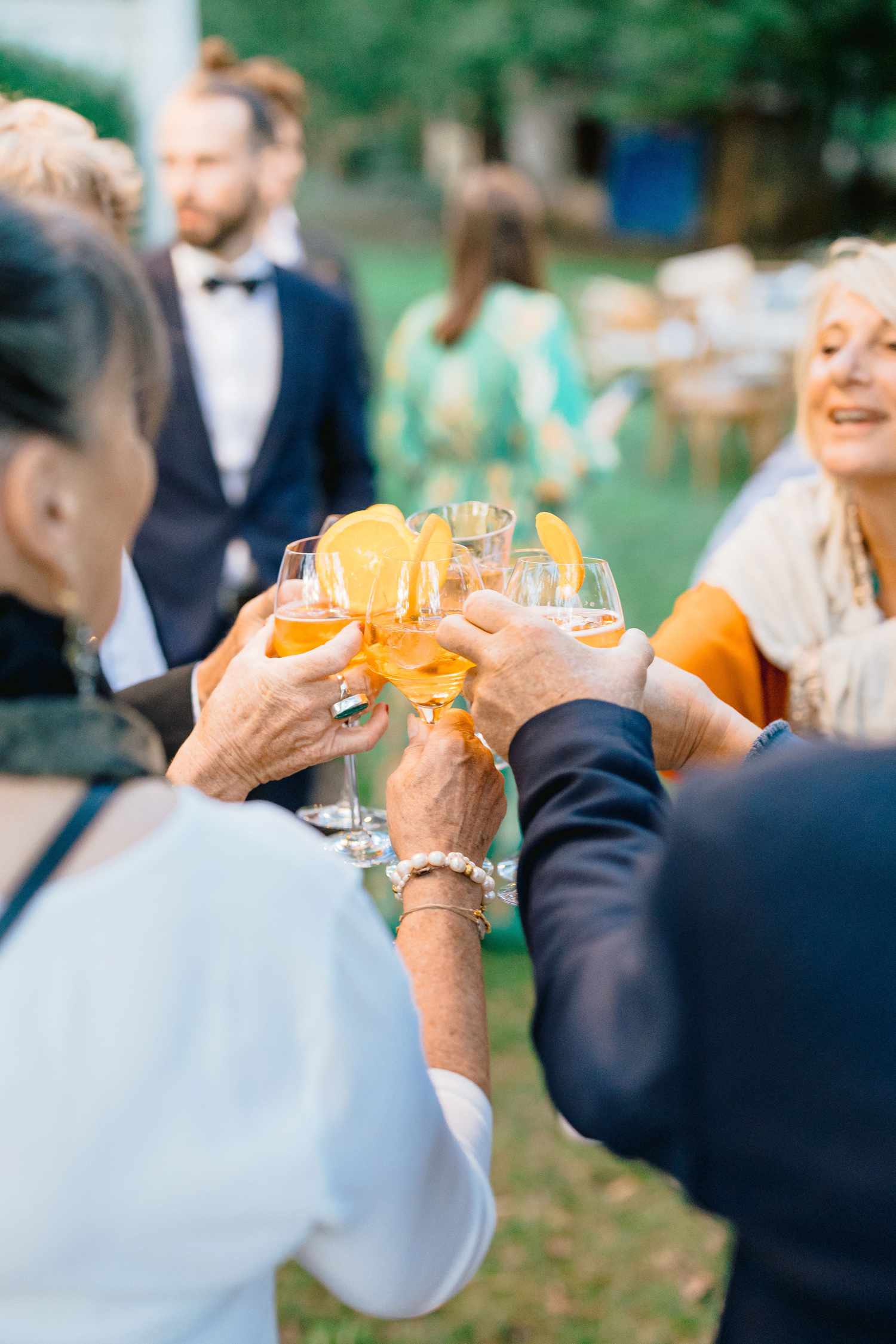 guests cheers with cocktail in hands