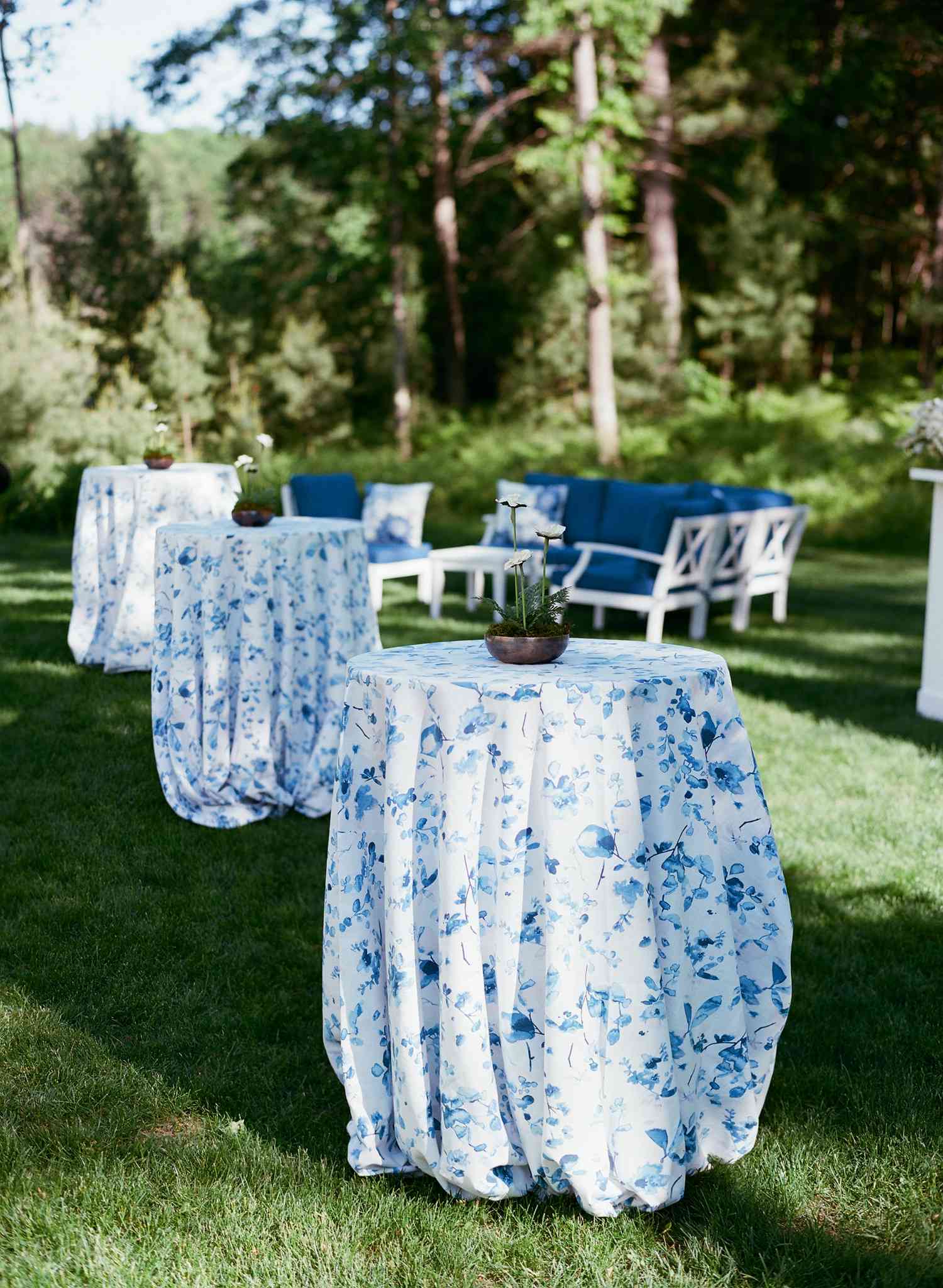 Cocktail tables draped in blue and white floral linens