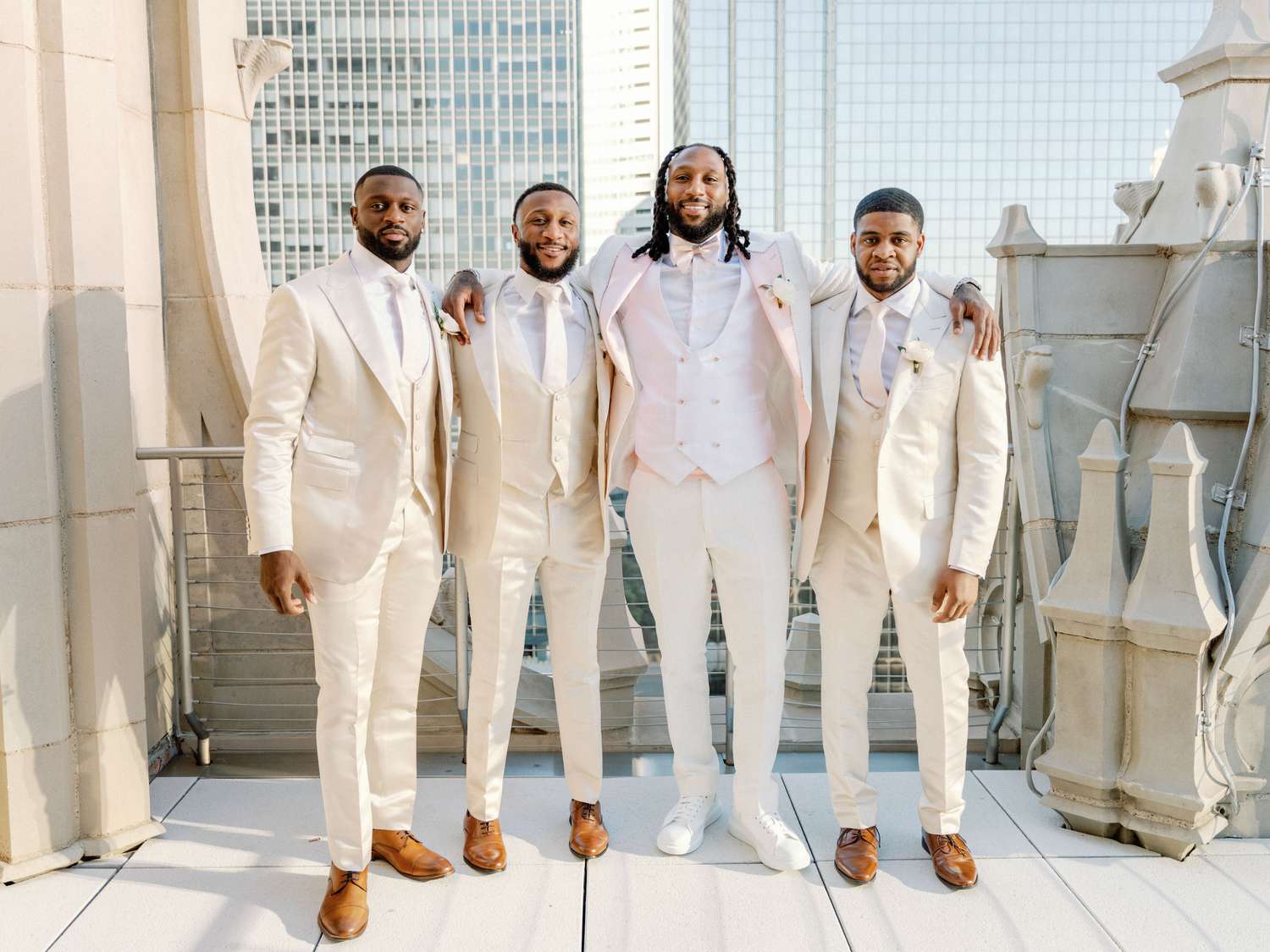 groom and groomsmen on a balcony with a city skyline view