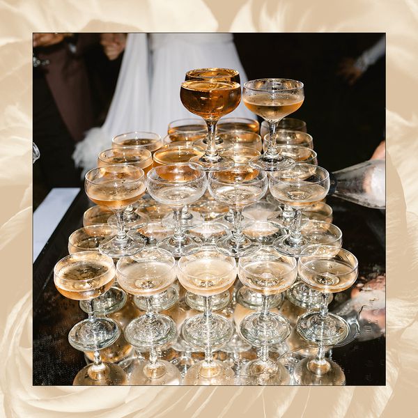 Pouring champagne over a champagne tower at a wedding.