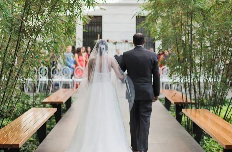Bride and her father walking down the aisle at the Cleveland art museum.