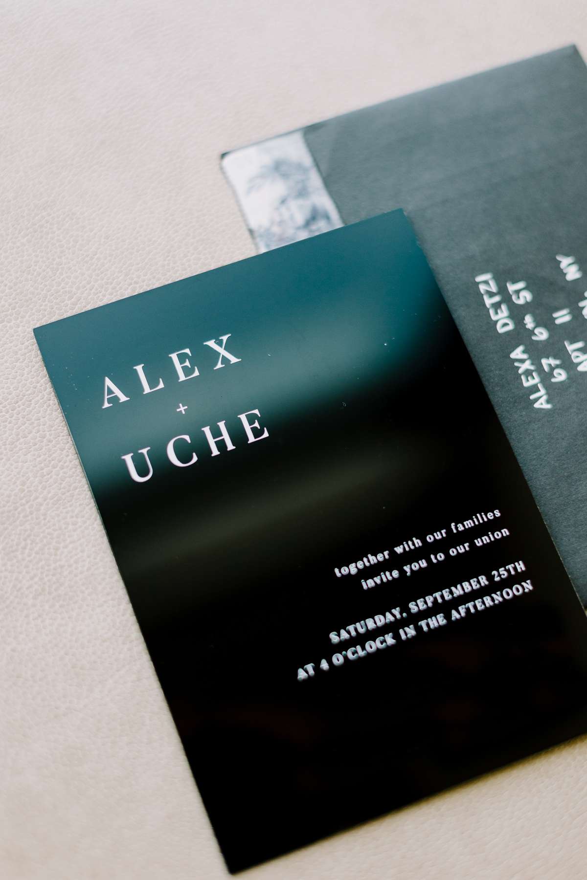 Alex and Uche's dark invitations with white font