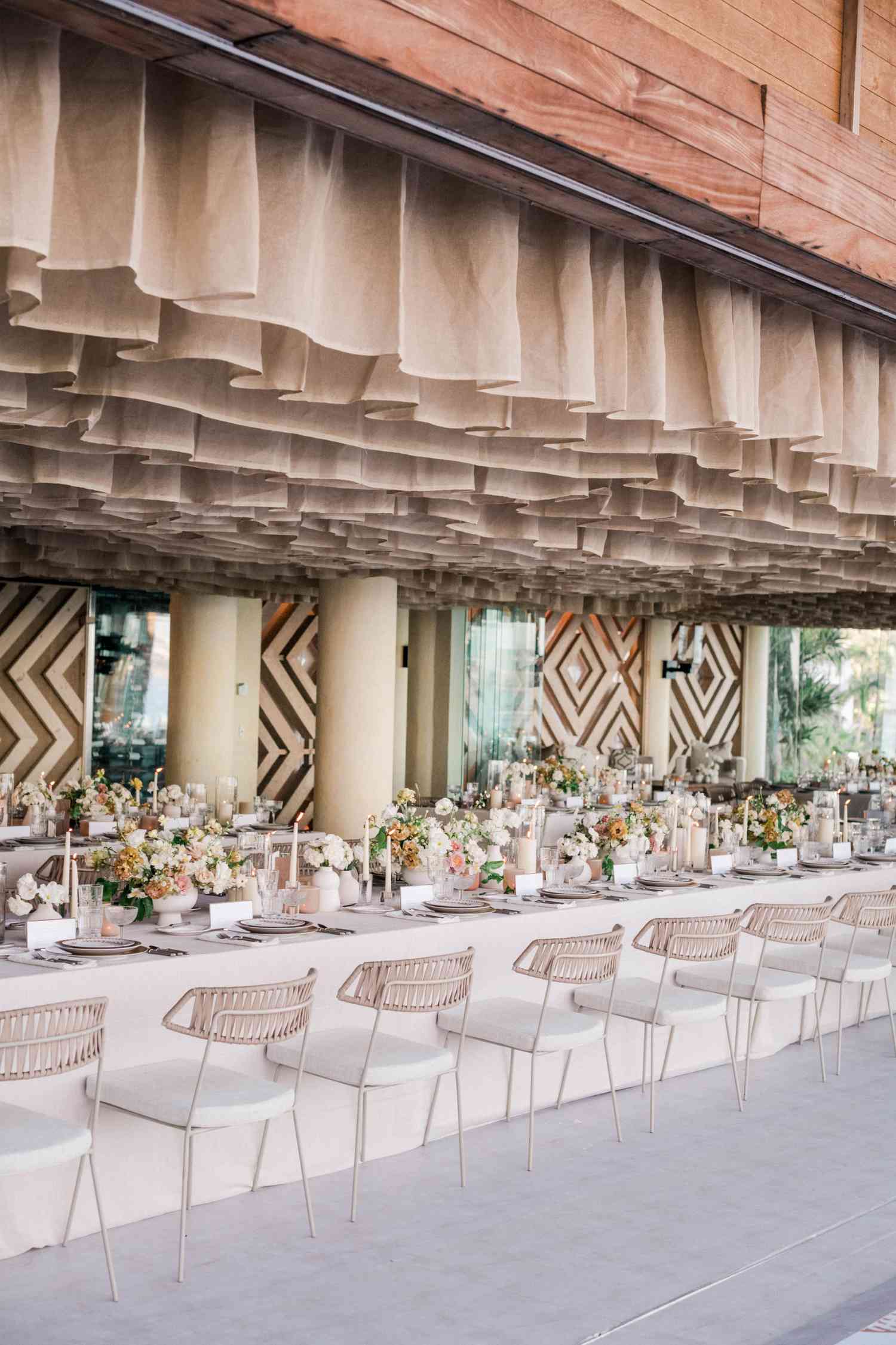 outdoor wedding reception with long table and short taupe draping overhead
