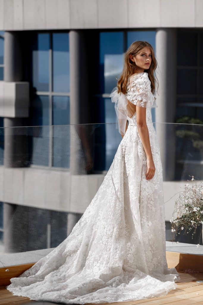 Model in floor-length embroidered wedding gown with cape