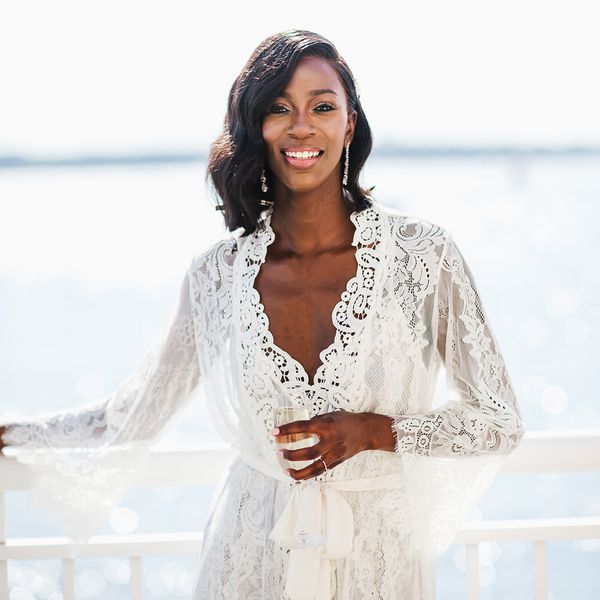 Smiling bride in robe on seafront balcony