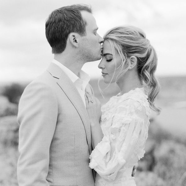 black and white photo of a man kissing his wife on her forehead