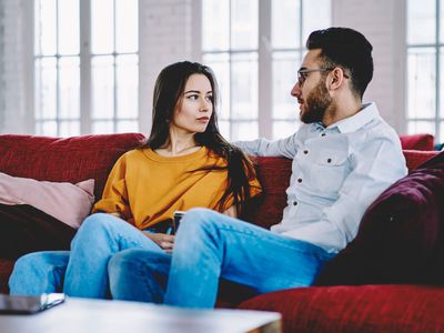 Boyfriend talking with girlfriend on a sofa in an apartment