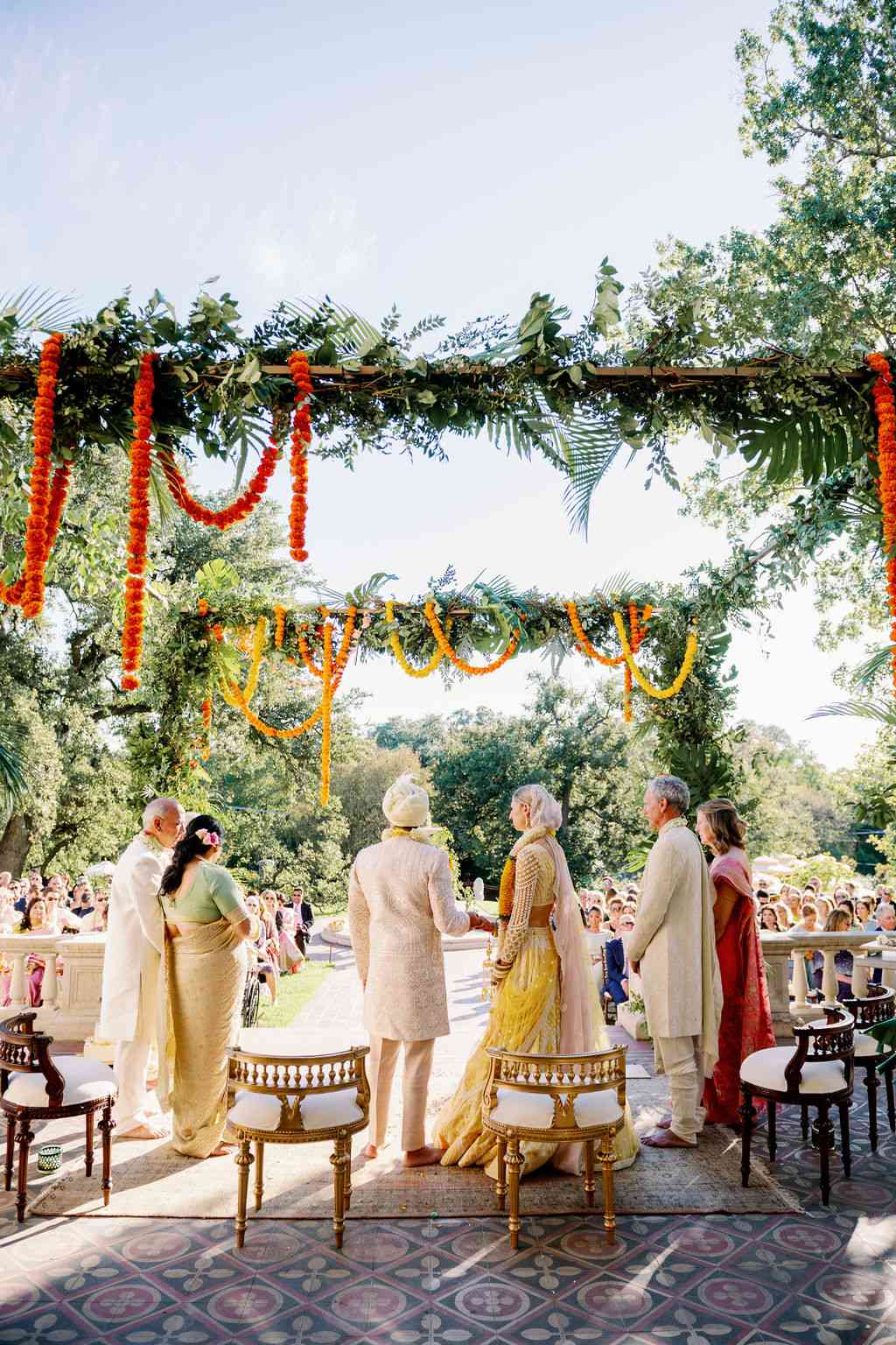 couple posing under a mandap with handing garland