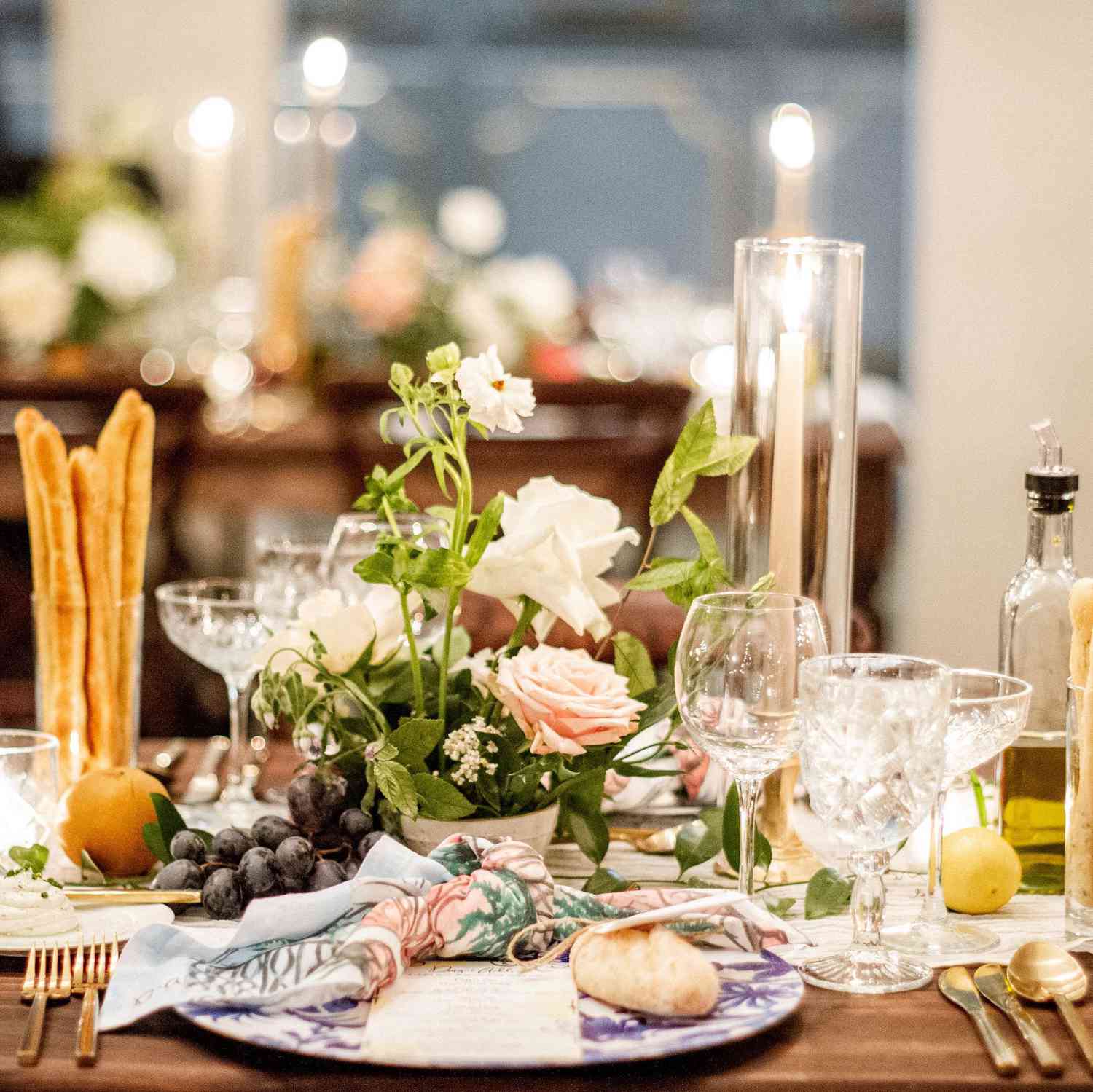 Wooden Table With Breadsticks, Fruit, Taper Candles, and Printed Napkins