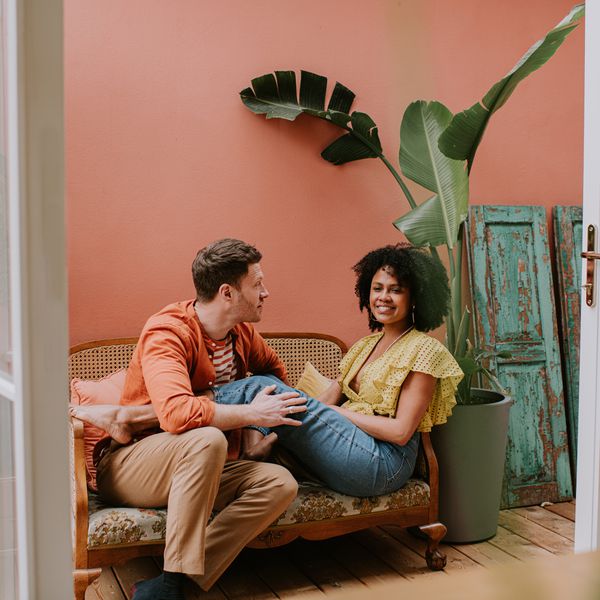 Attractive Younger Couple Smiling While Talking Sitting on the Couch