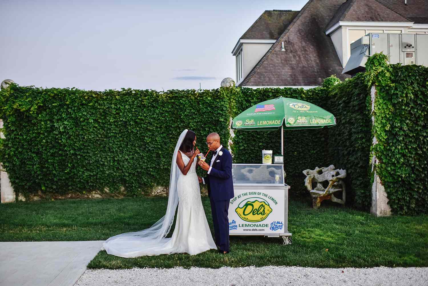 Couple with lemonade stand at backyard wedding