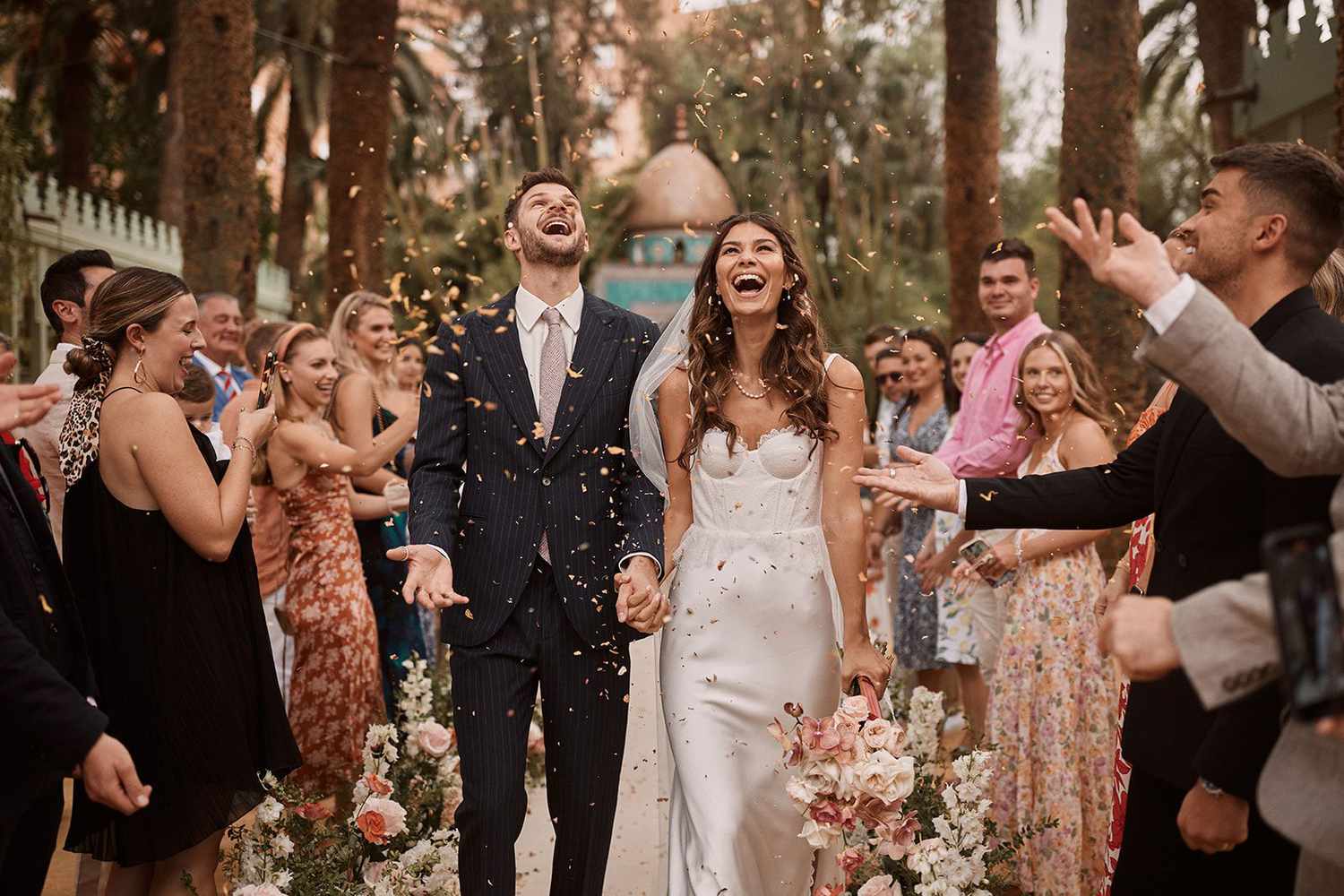 Jim Chapman and Sarah Tarleton walk down the aisle under tossed petals