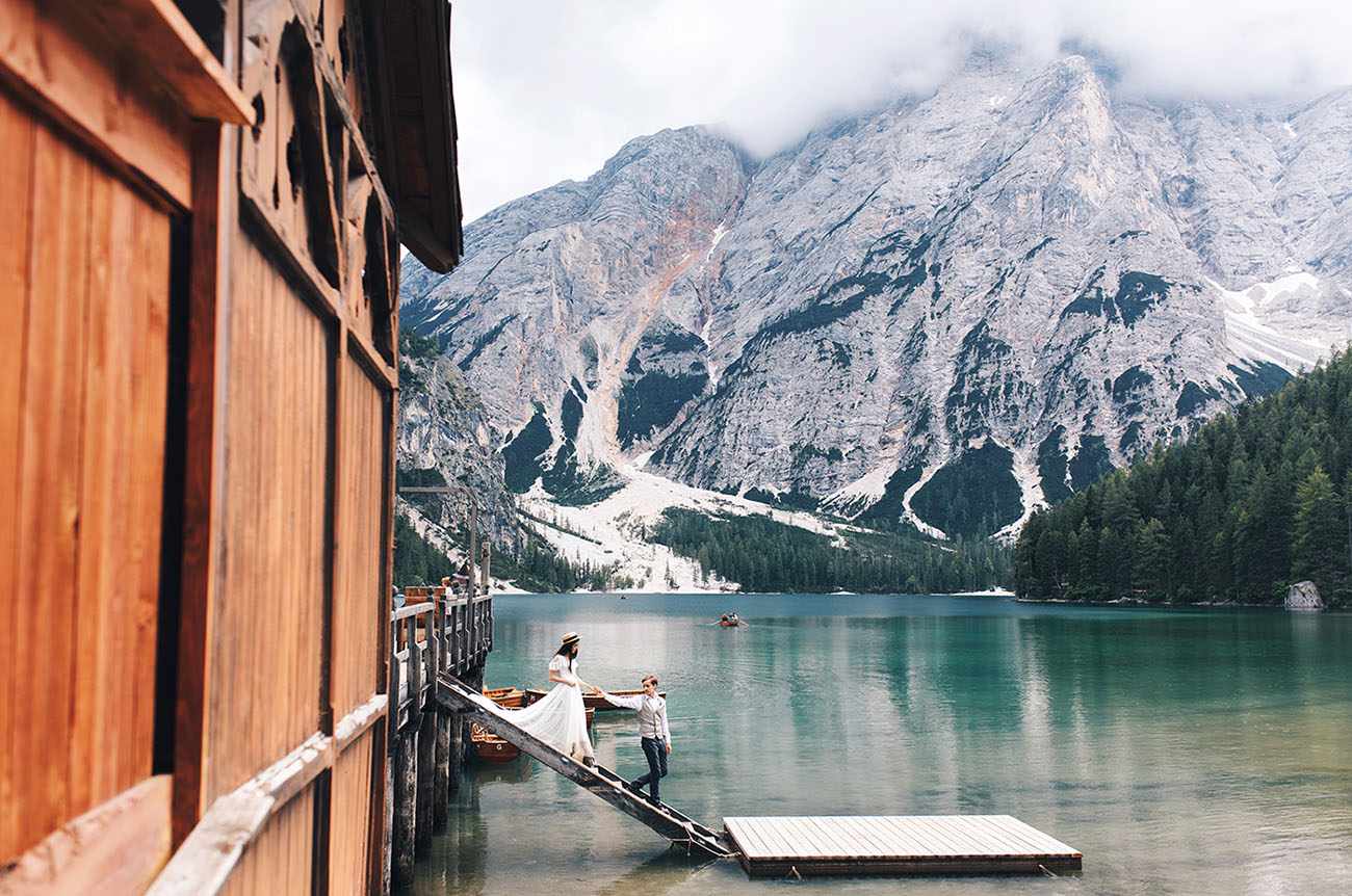 Couple Walks Down to the Lake in Front of the Mountains During Their Destination Elopement in the Dolomites