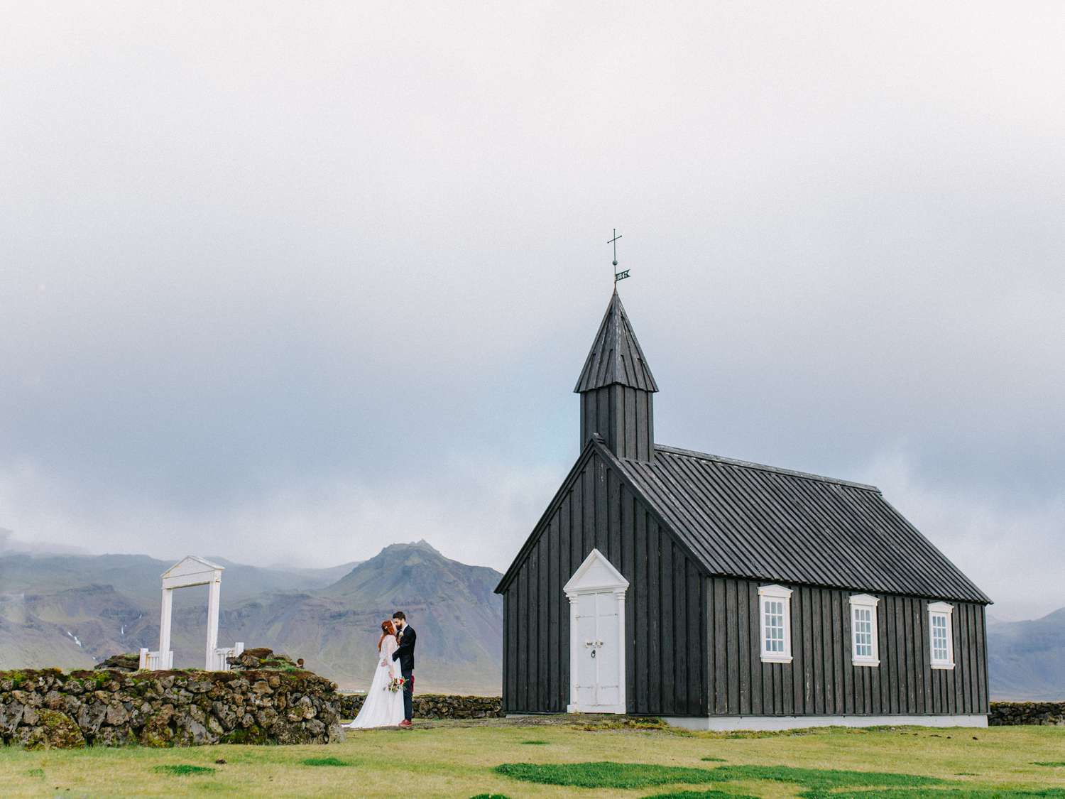 Couple Shares a Kiss In Front of a Church at Their Iceland Destination Elopement