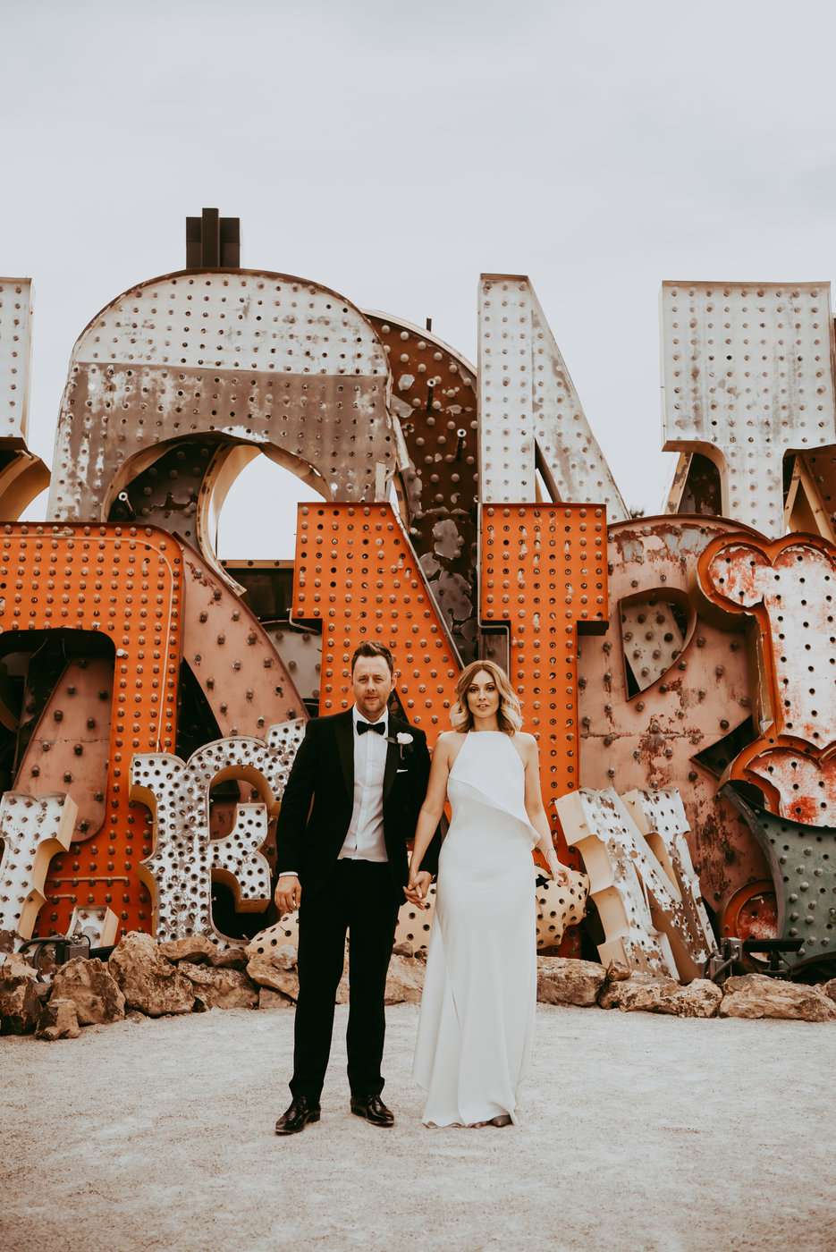 Couple Stands in Front of an Orange Sign in Las Vegas for an Elopement