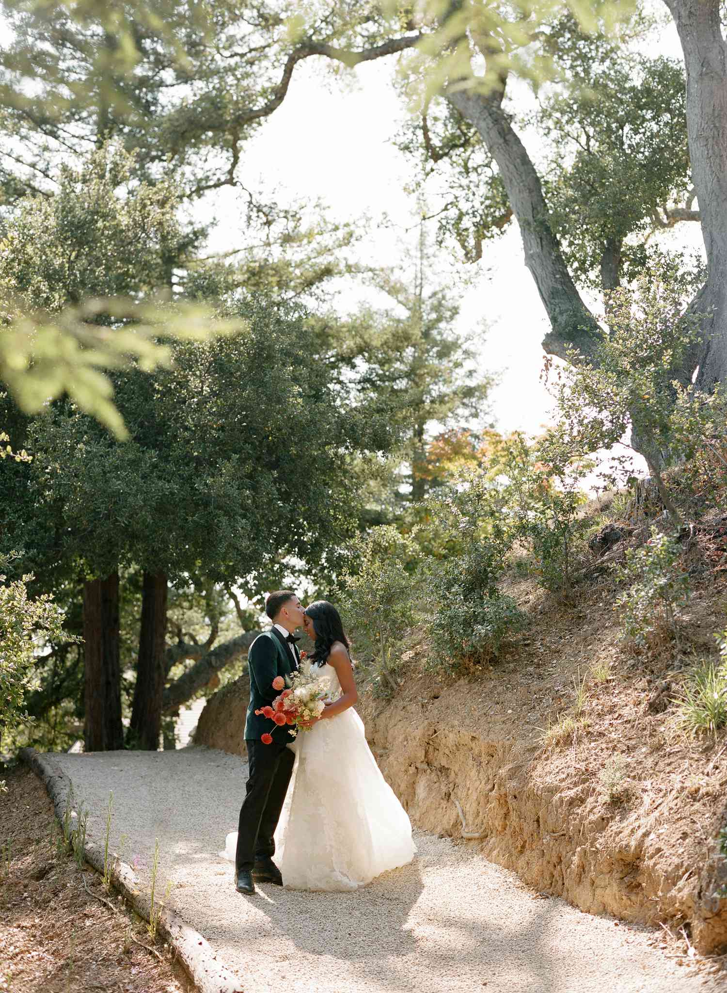Couple Shares a Kiss on a Path Through the Woods at Their Destination Wedding in Big Sur, California