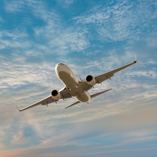 airplane flying in sky during sunset