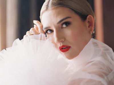 beauty shot of a bride bold red lips and a slicked back bun
