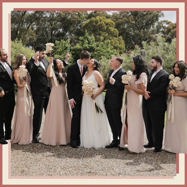 Bride in Wedding Dress Posing With Groom in Suit and Wedding Party