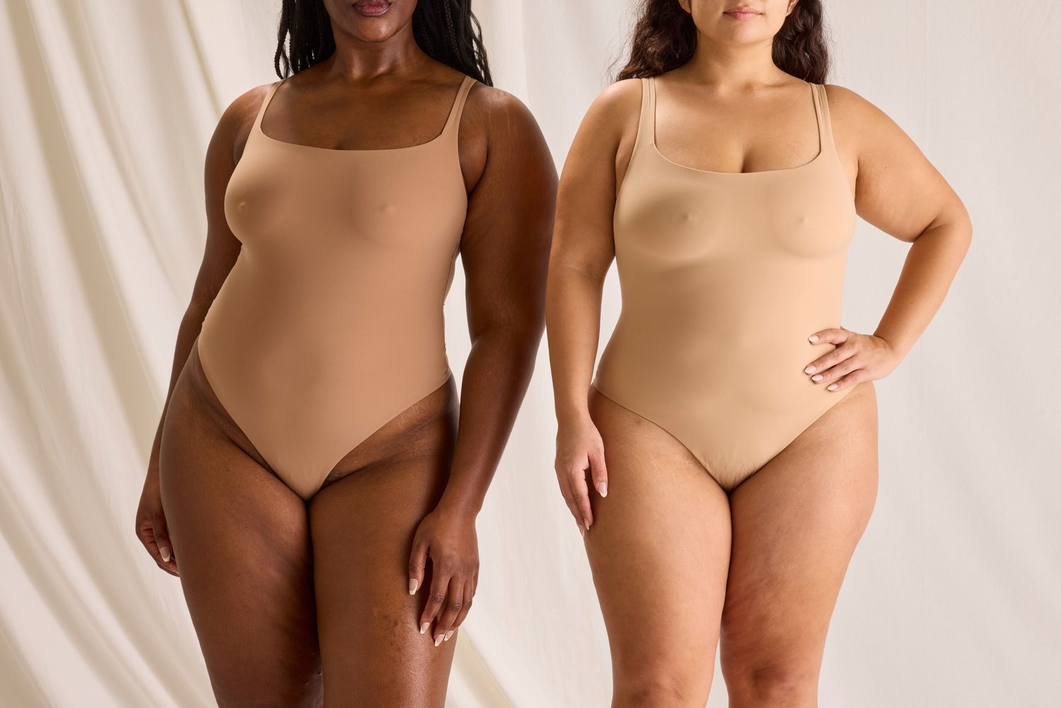 Two women wearing the SKIMS 'Fits Everybody' Sculpting Bodysuit in tan