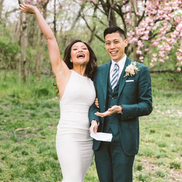 bride and groom outdoors in front of a cherry blossom tree