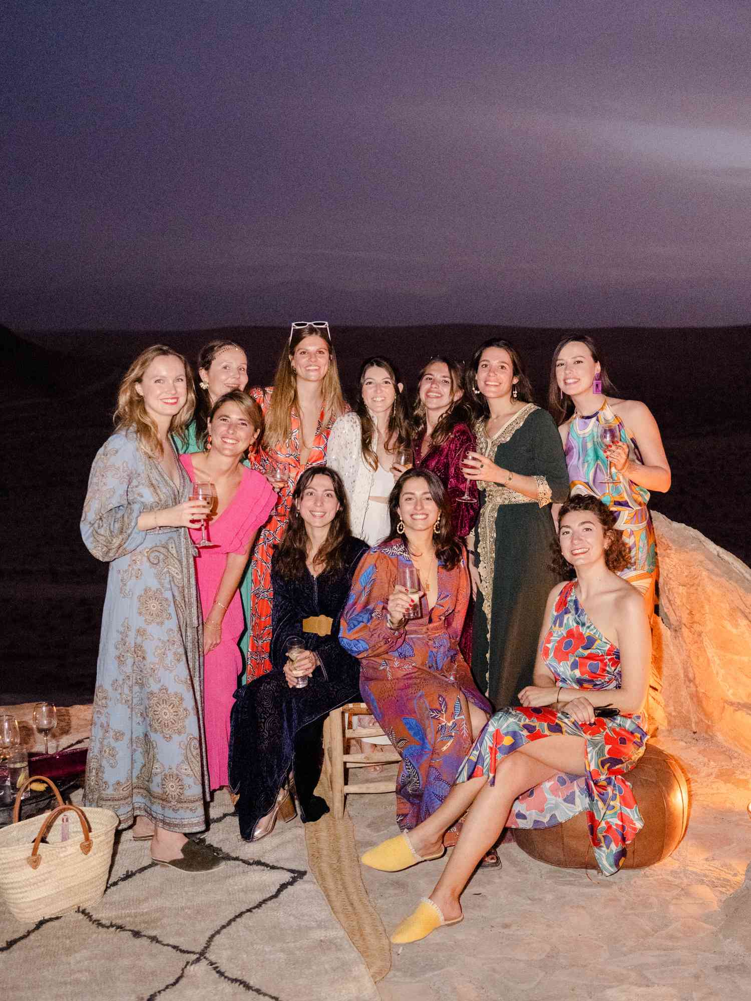 group of women sitting outside in a desert