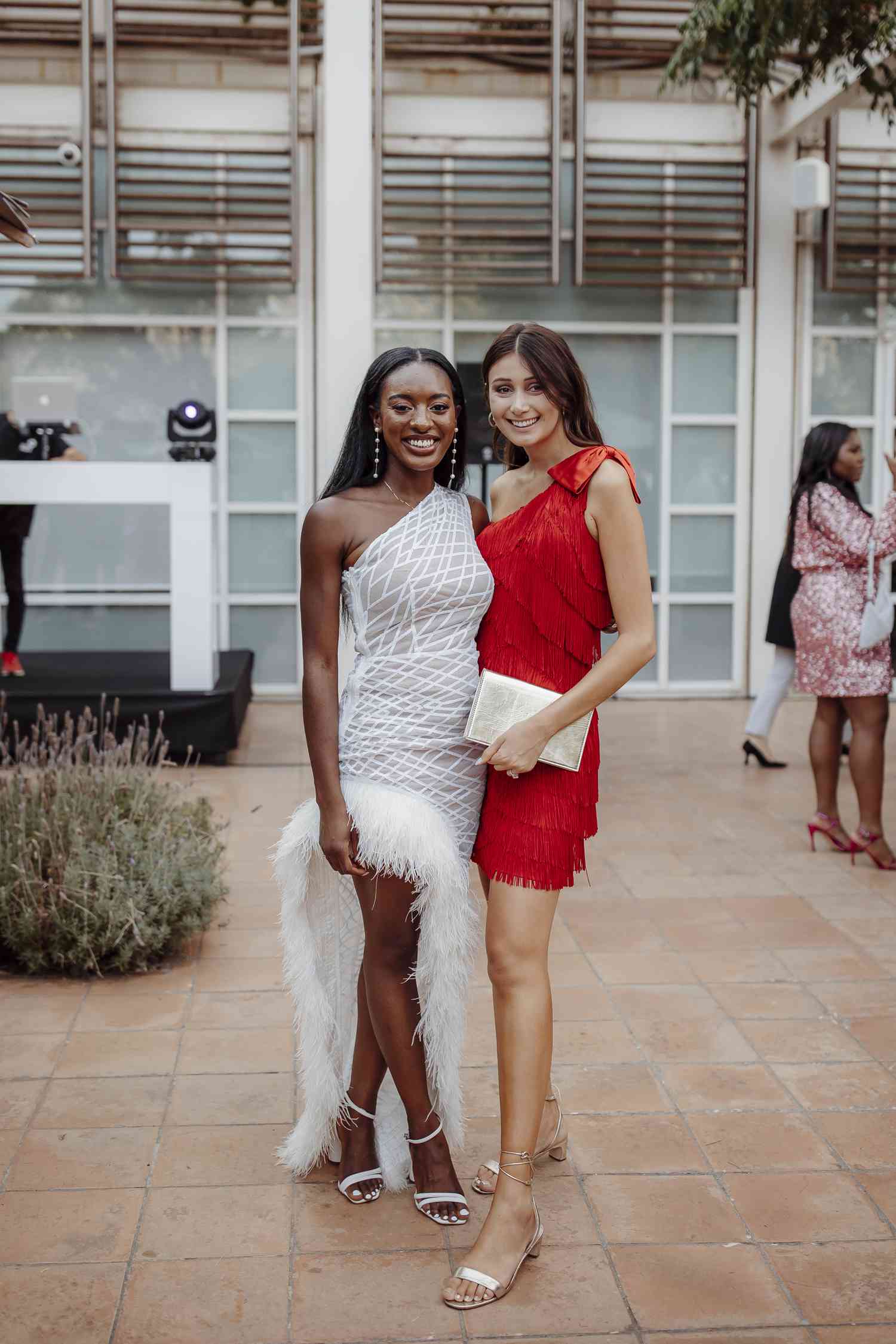 wedding guest in red mini dress and bride in white column dress