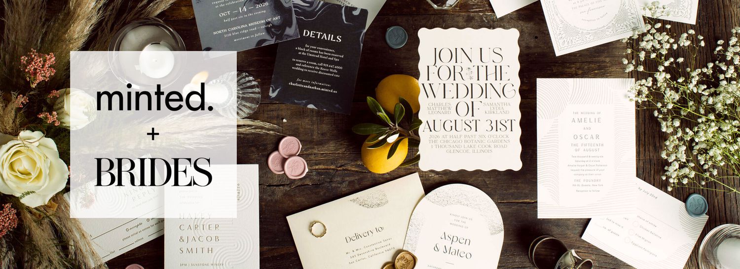 Invitations from the Minted + Brides Trends Stationery Collection displayed on a wooden table
