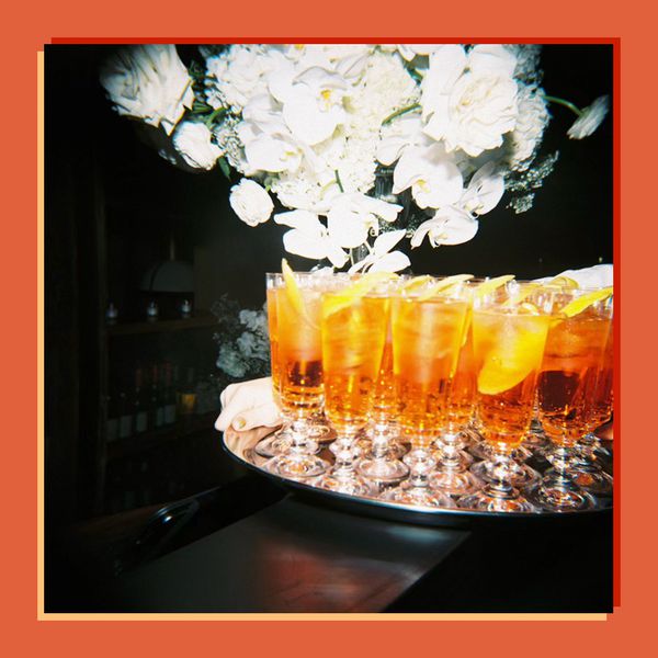 Orange Cocktails on Silver Tray Next to White Flowers at Wedding Reception