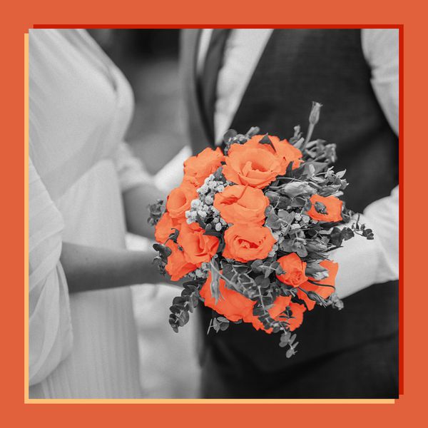 Black and White Image of Bride in Wedding Dress and Groom in Suit Holding Flower Bouquet With Pops of Verona Sunset Color