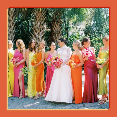 Bride in Long Sleeve Wedding Dress Posing With Bridesmaids in Bright Verona Sunset, Pink, and Yellow Dresses 