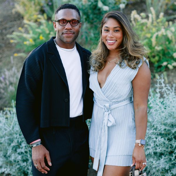 male and female wedding guests: The man is wearing a black jacket and pants with a shirt and the woman is wearing a light blue romper