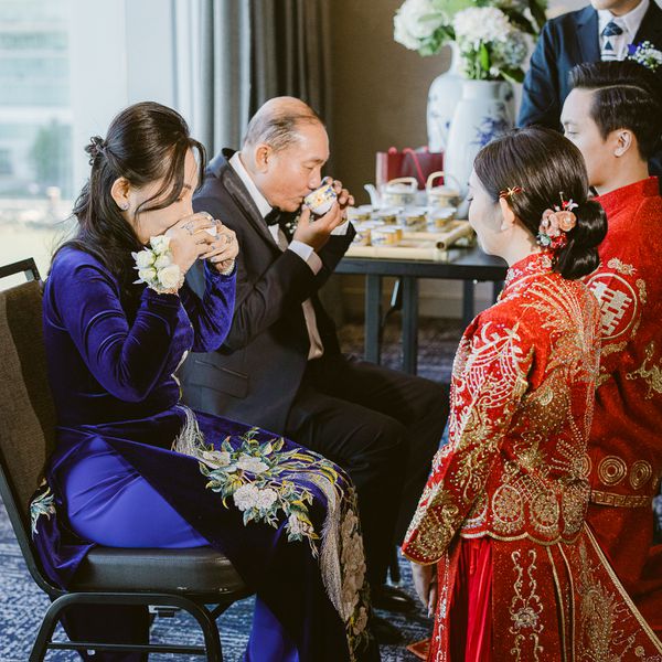 Mother and Father Sitting on Chairs and Drinking Tea While Bride and Groom Kneel Before Them