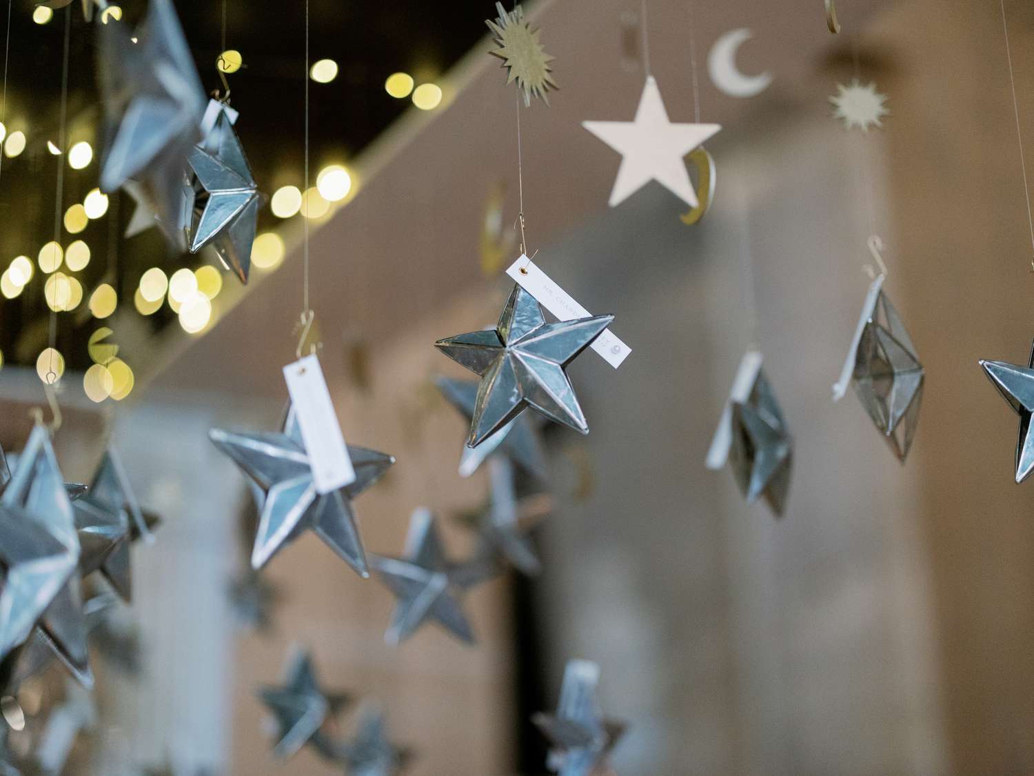 Silver star ornaments as escort cards hanging from a gazebo