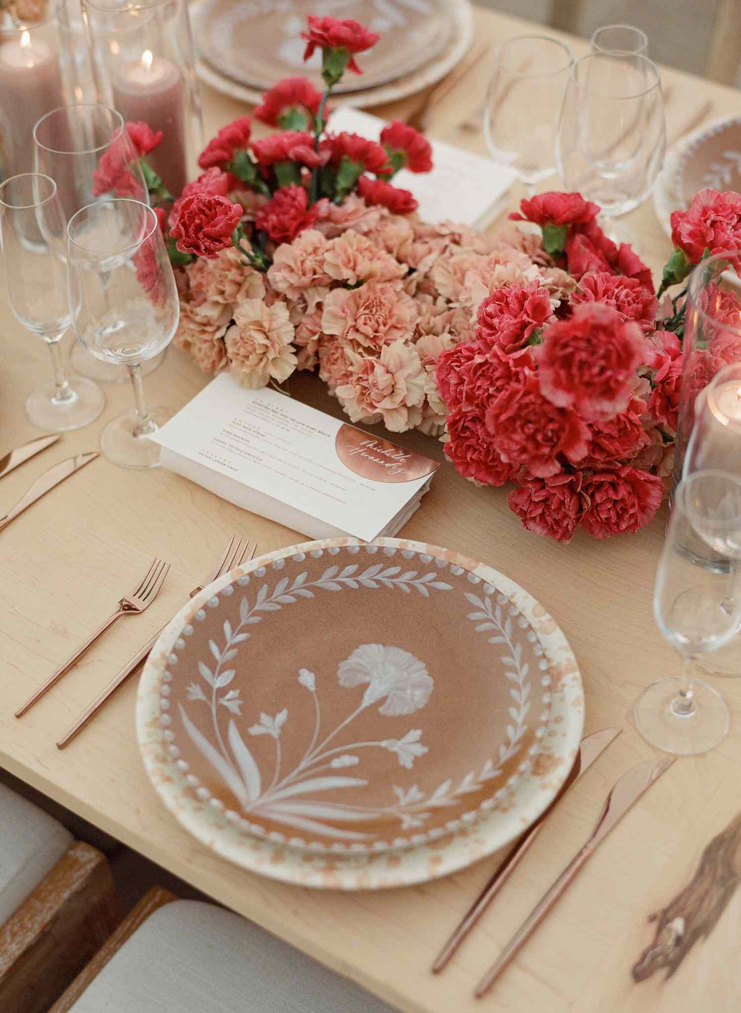 Brown floral ceramic plates and speckled chargers at wedding tablescape with pink florals