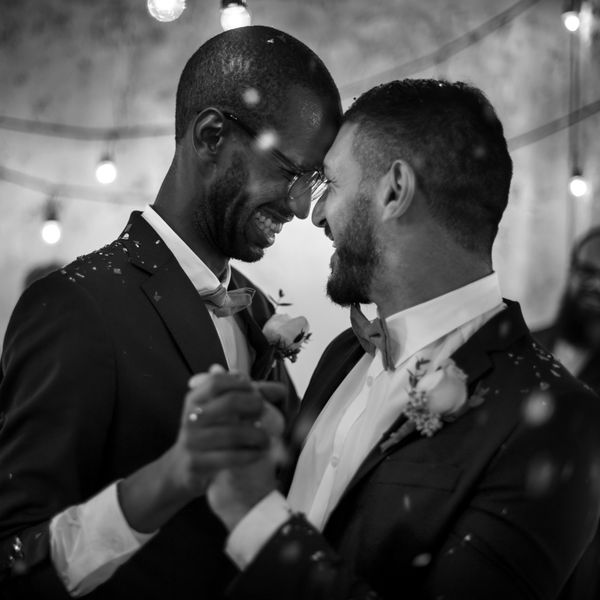 Two Grooms in Tuxedos and Boutonnieres Dancing on Wedding Day