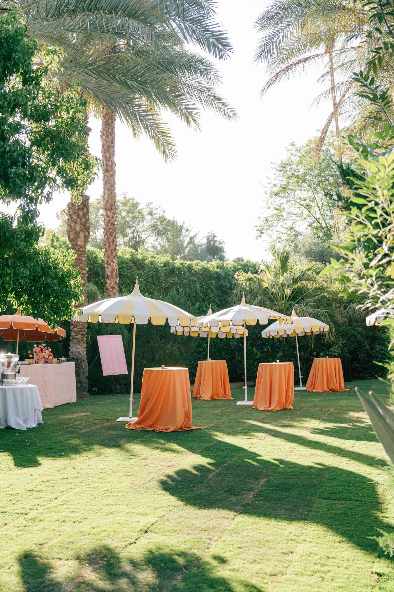 Grassy Area With High-Top Tables in Orange Linens and Yellow Umbrellas