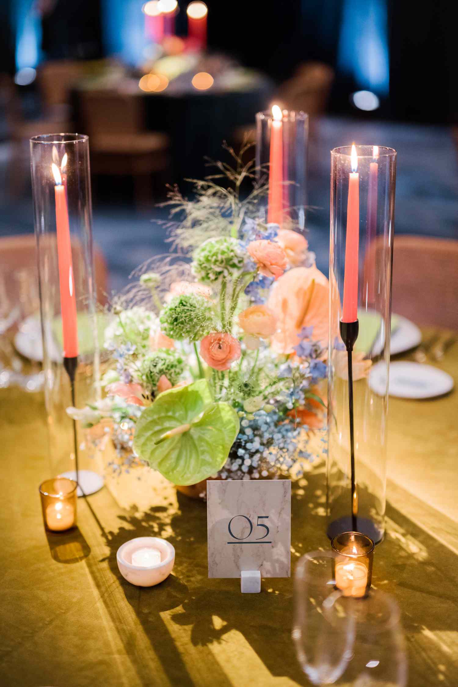 Tropical Wedding Centerpieces with Ranunculus, Carnations, and Anthurium with Pink Taper Candles and Table Number