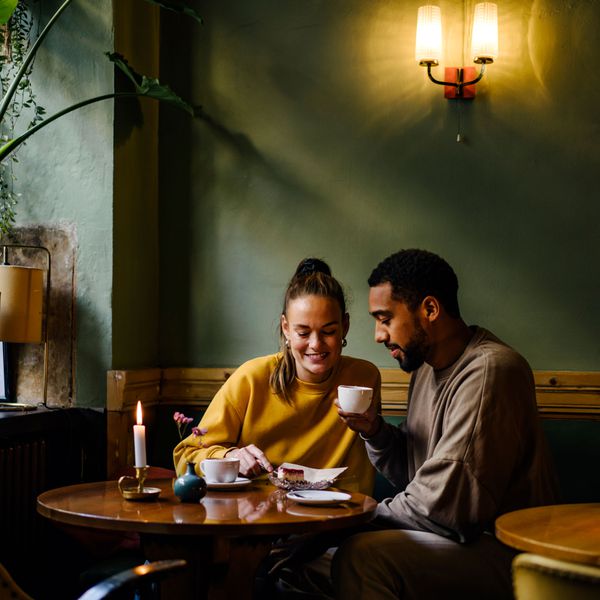 Couple Eats Cake and Drinks Coffee While Sitting Inside on a Rainy-Day Date
