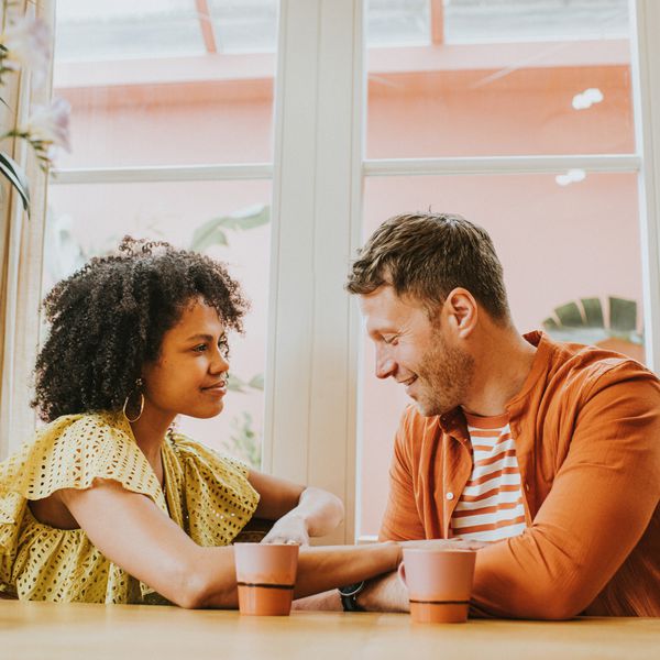 Couple Flirting at Restaurant Table While Holding Hands