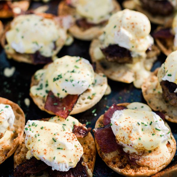 An Array of Eggs Benedict on English Muffins With Chives, Bacon, and Seasoning