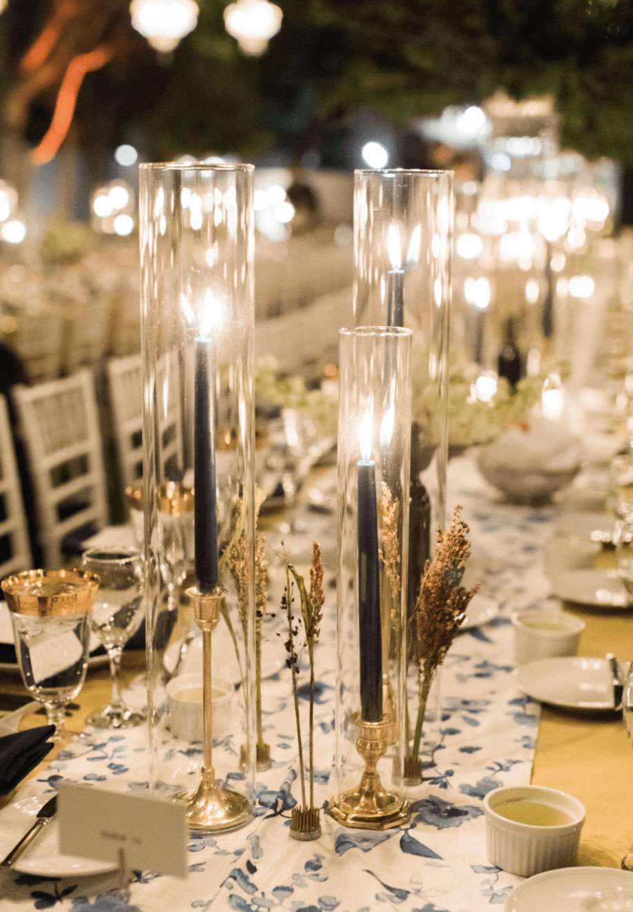 Wedding reception tablescape with blue taper candles in glass votives