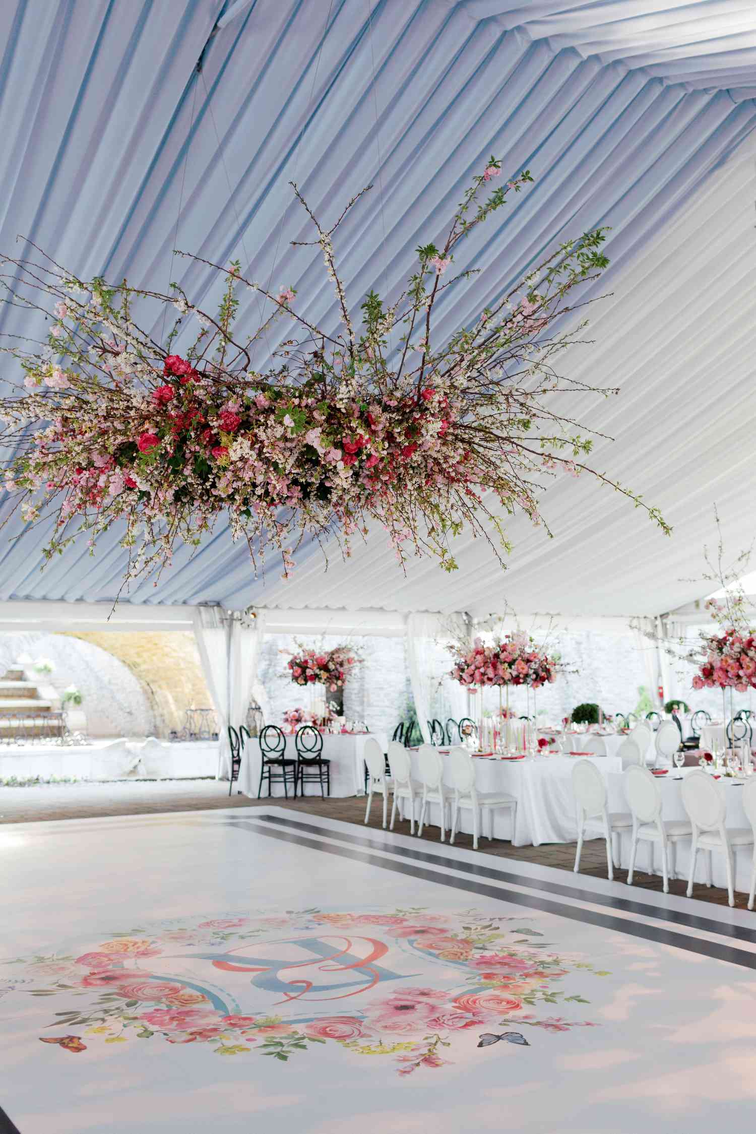 Monogrammed dance floor with pink, red, and white flower chandelier above it