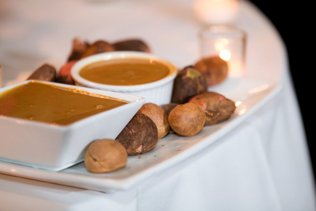 Kola Nuts on White Tray With Two Bowls of Dipping Sauce