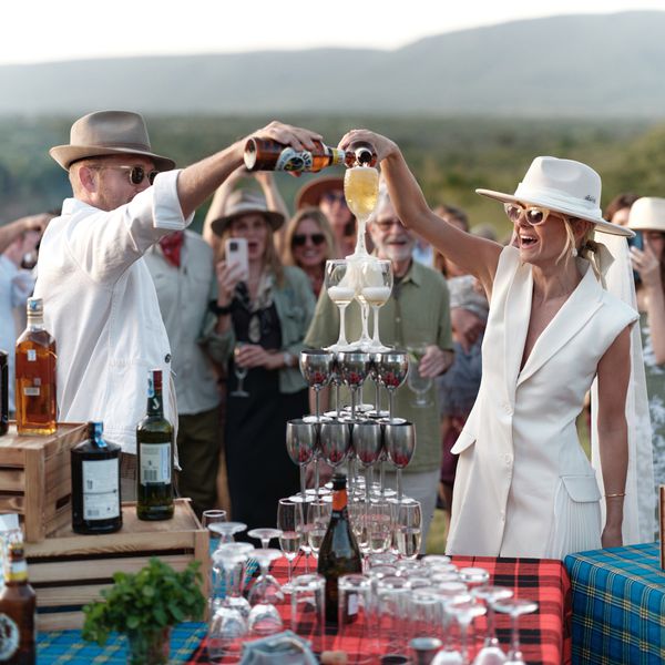 Engaged Couple in White Attire Pouring Beer Into Beer Tower at Engagement Party